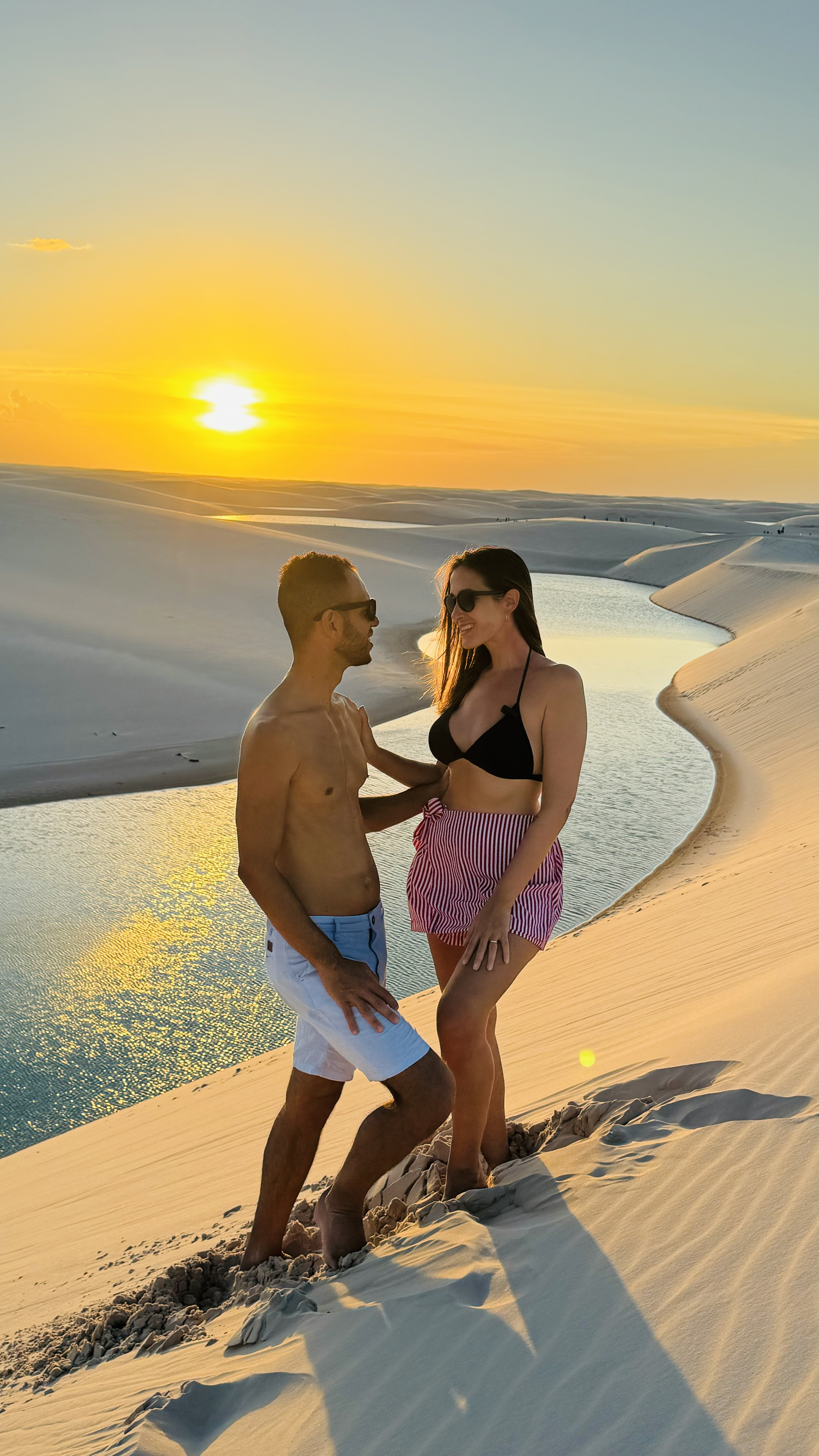 Casal ao pôr do sol na Lagoa Bonita, nos Lençóis Maranhenses