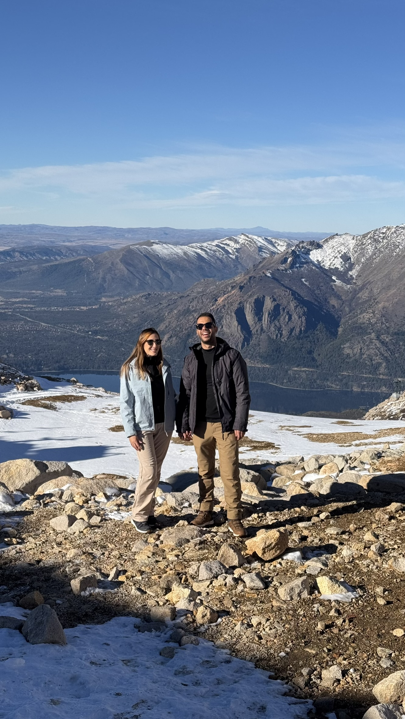 Casal em mirante com neve no Cerro Catedral, com o Lago Nahuel Huapi ao fundo