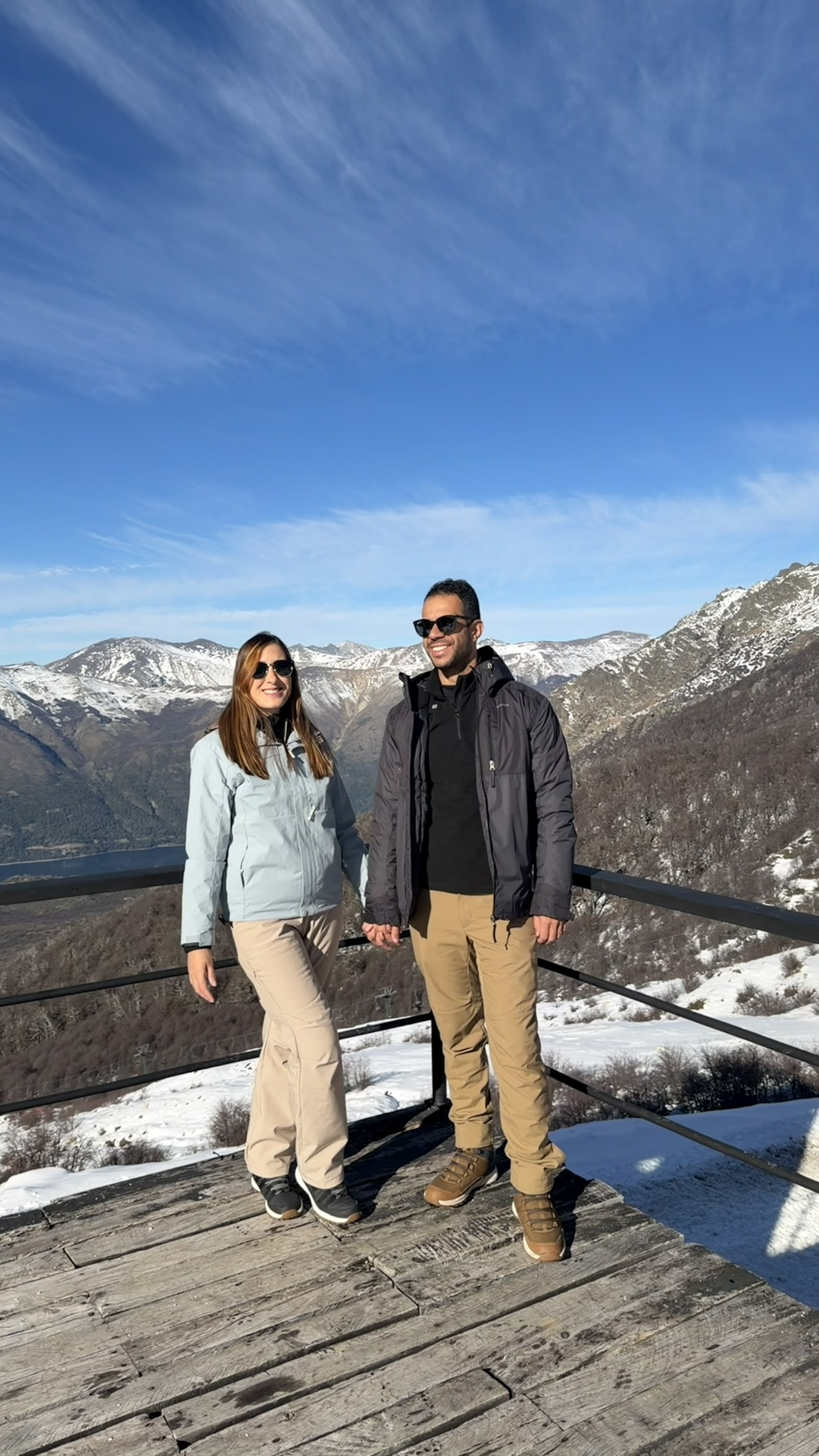 Casal no deck de um mirante nevado do Cerro Catedral, em Bariloche