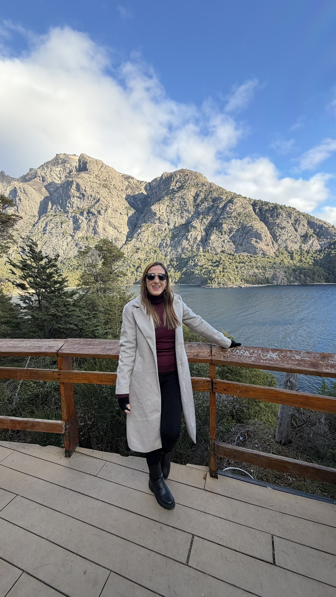 Viajante em mirante de madeira com lago e montanhas no Circuito Chico, em Bariloche