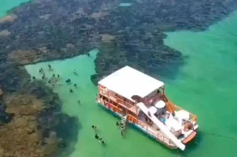 Barco com escorregador ancorado nas piscinas naturais de João Pessoa
