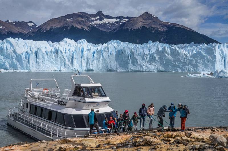 Barco com passageiros diante da parede de gelo do Perito Moreno no Safari Azul