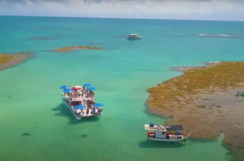 Barcos nas piscinas naturais de água verde em João Pessoa
