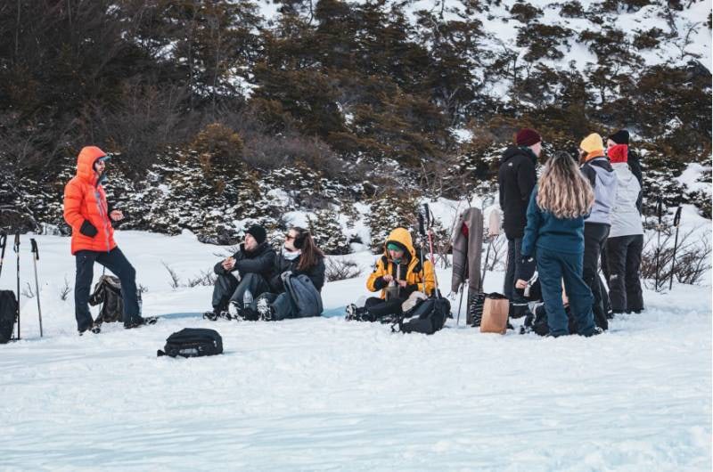 Caminhantes descansando na neve durante o trekking em Ushuaia