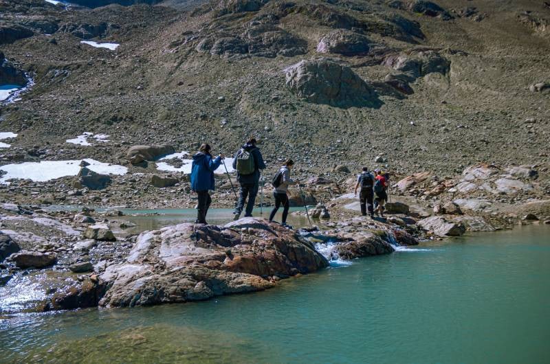 Caminhantes nas pedras junto à Laguna de los Témpanos