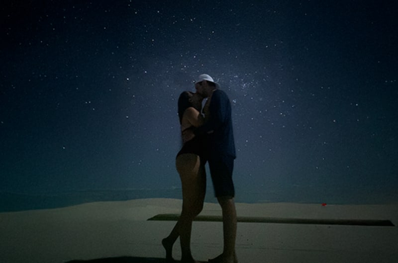 Casal se beijando sob as estrelas nas dunas dos Lençóis