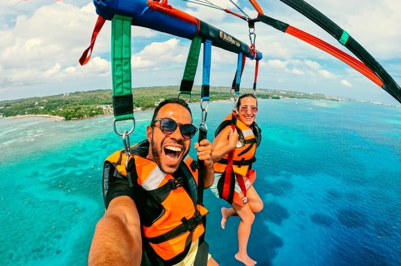 Casal voando de parasail sobre o mar de San Andrés