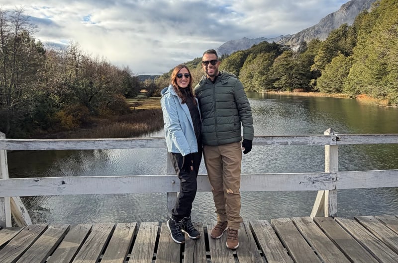 Casal em deck de madeira à beira de lago no caminho do Cerro Tronador