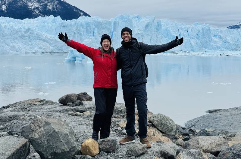 Casal na margem do lago diante do Glaciar Perito Moreno