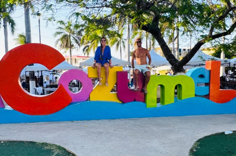 Casal no letreiro colorido de Cozumel