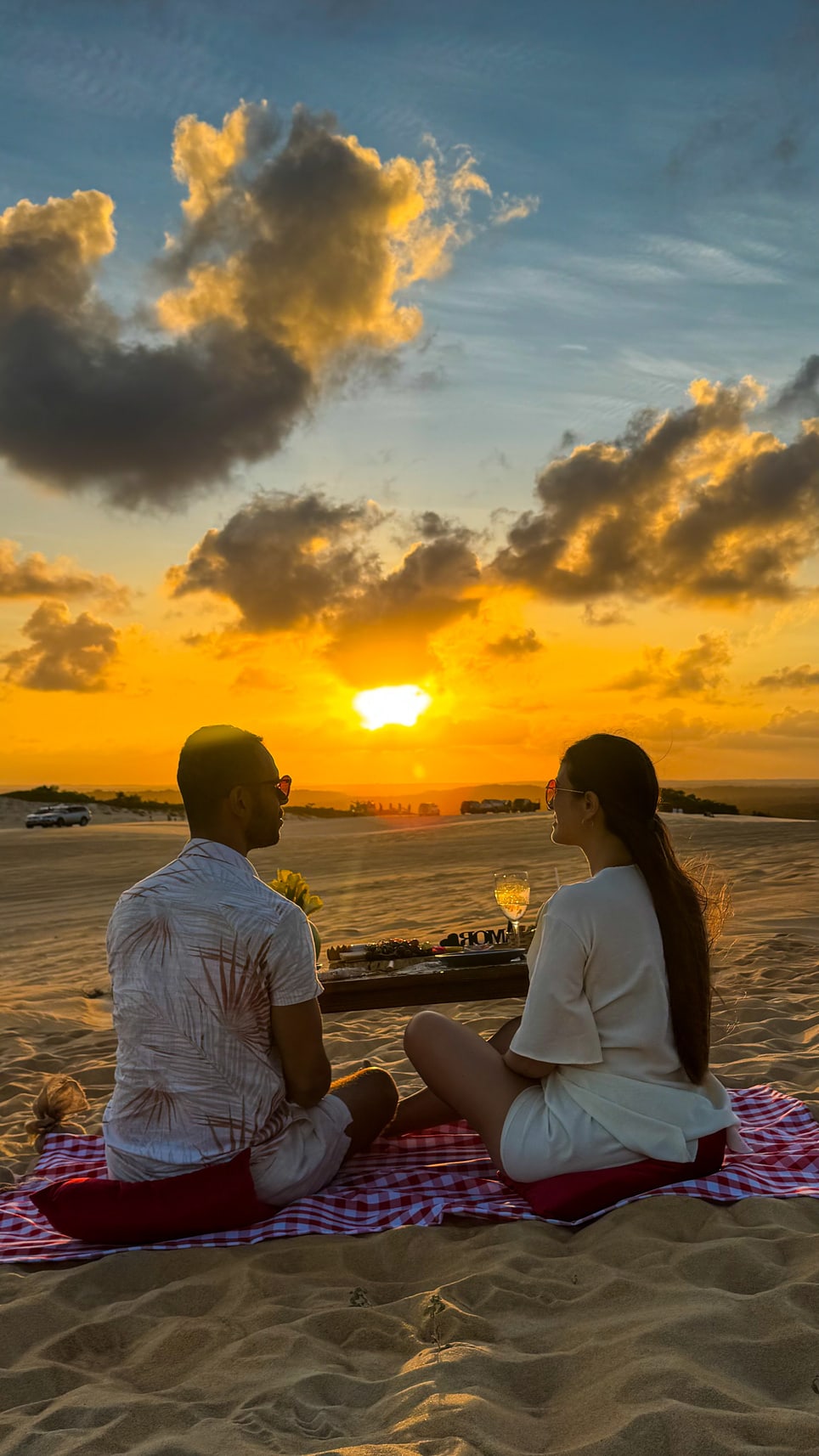Casal no piquenique ao pôr do sol nas Dunas de Búzios, em Natal