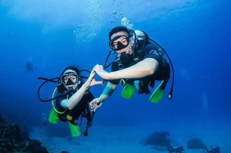 Dupla fazendo mergulho de batismo com cilindro em Noronha