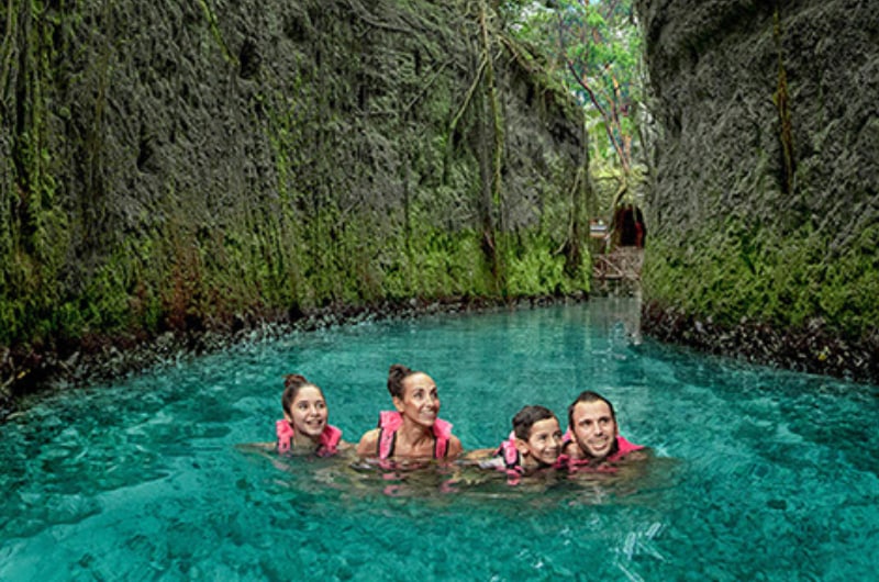 Família nadando no rio subterrâneo do Parque Xcaret