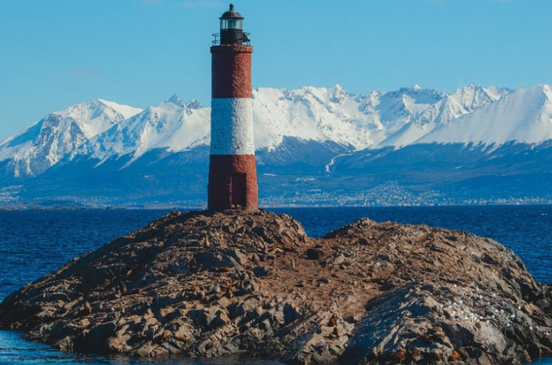 Farol Les Eclaireurs com as montanhas nevadas de Ushuaia ao fundo