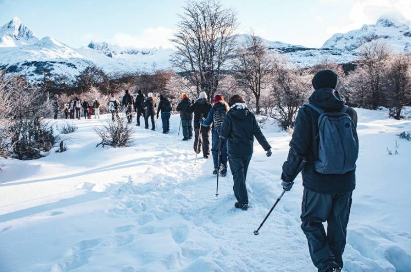 Fila de caminhantes na trilha nevada da Laguna Esmeralda