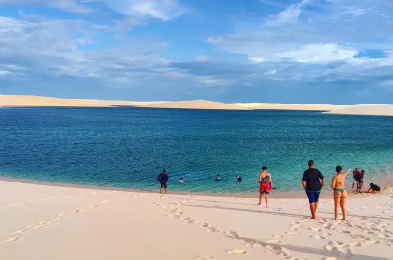 Grupo caminhando na areia até a lagoa em Santo Amaro do Maranhão