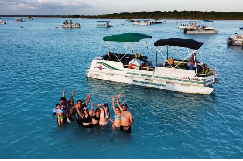 Grupo na água ao lado do barco pontón na Laguna de Bacalar