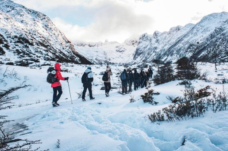 Grupo no vale nevado entre as montanhas na trilha da Laguna Esmeralda