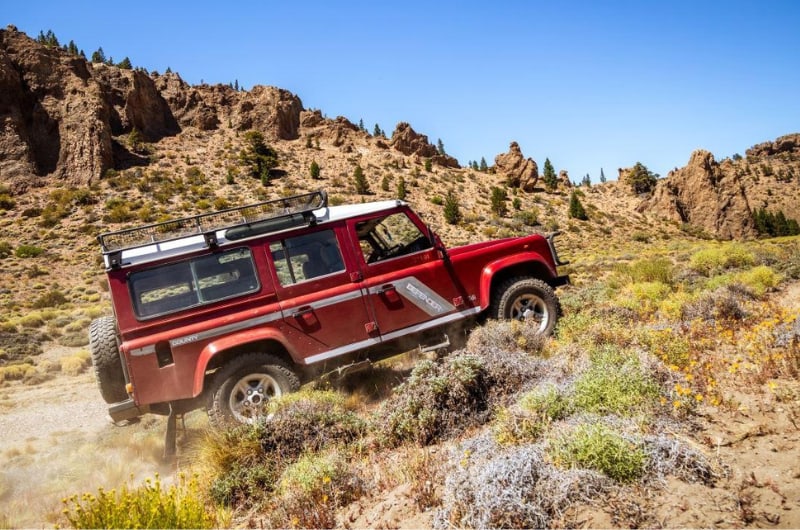 Land Rover Defender subindo terreno de pedras na estepe perto de Bariloche
