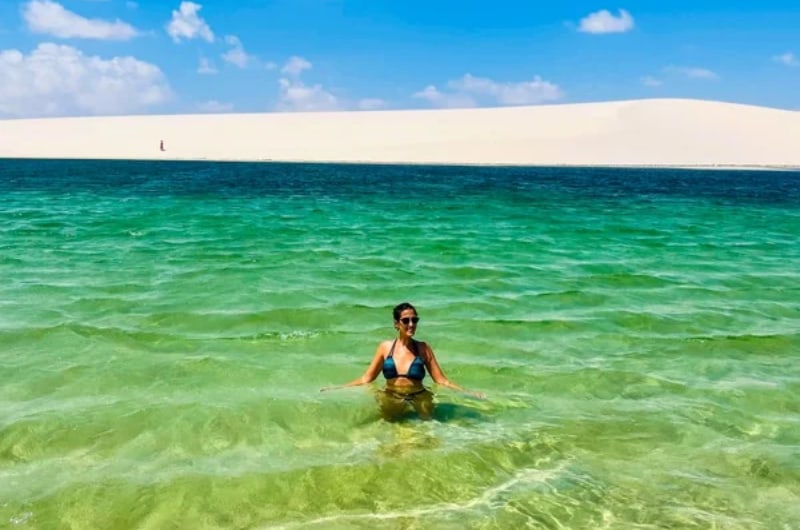 Viajante numa lagoa verde nos Lençóis Maranhenses, em Santo Amaro