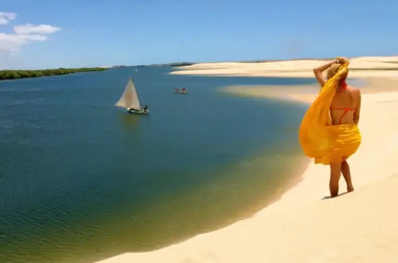 Viajante de vestido amarelo na margem do rio em Galinhos