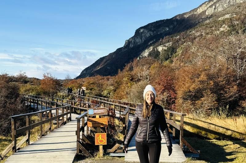 Viajante em passarela do parque com montanhas de outono, em Ushuaia