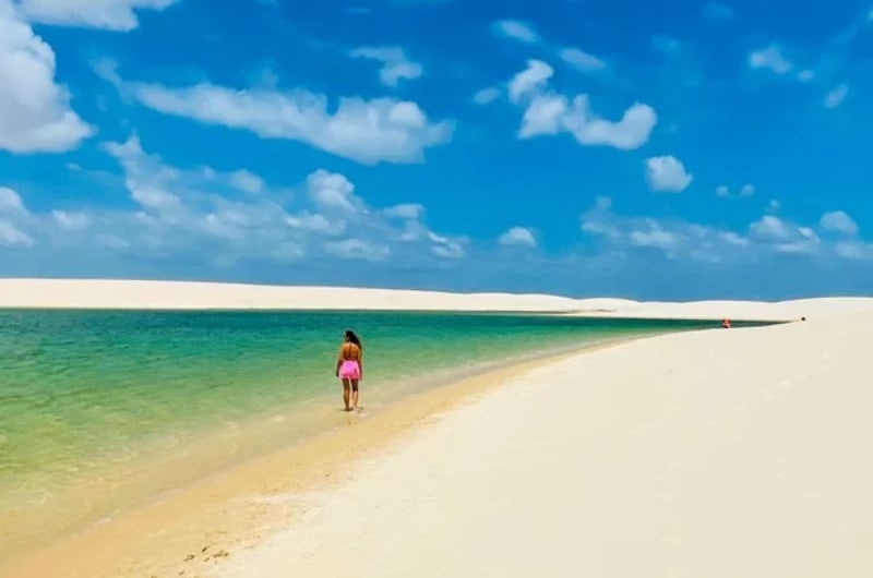 Viajante na faixa de areia entre lagoa e dunas no Circuito Betânia, em Santo Amaro