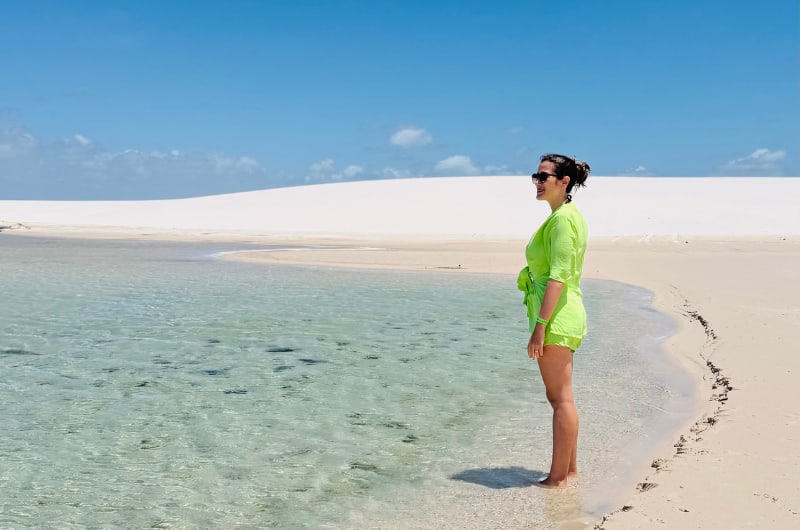 Viajante na margem de lagoa cristalina nos Lençóis Maranhenses
