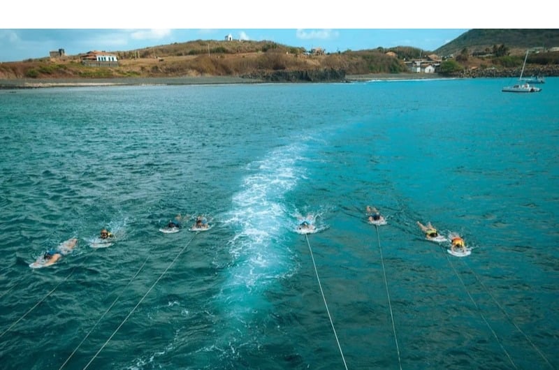 Viajantes fazendo planasub rebocados pelo barco em Noronha