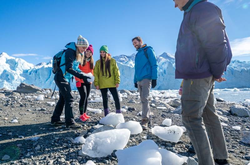 Viajantes com pedaços de gelo na margem do Lago Rico, no Perito Moreno