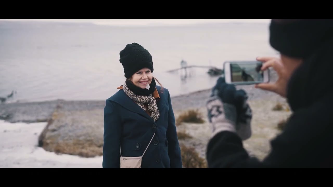 Viajante posando para foto à beira de um lago na expedição 4x4 de inverno em Ushuaia
