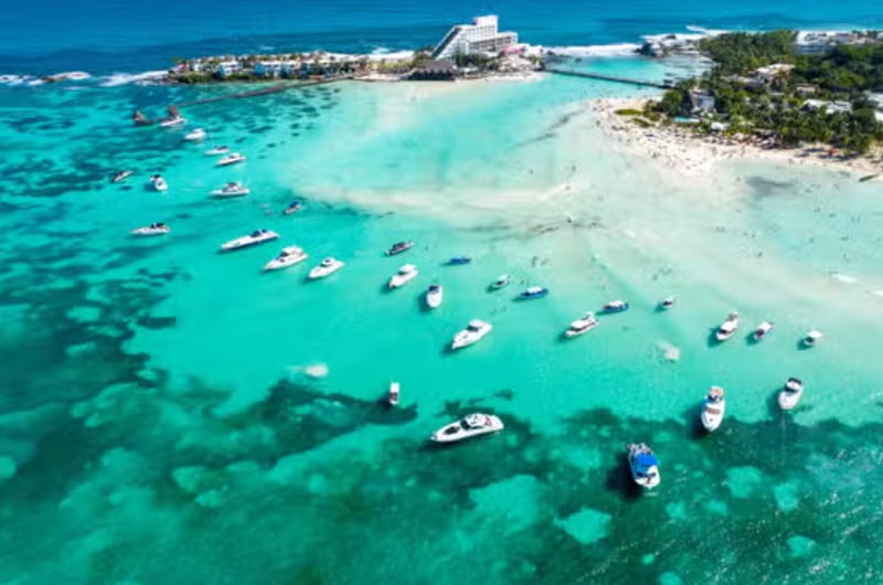 Vista aérea da Playa Norte em Isla Mujeres com barcos no mar turquesa
