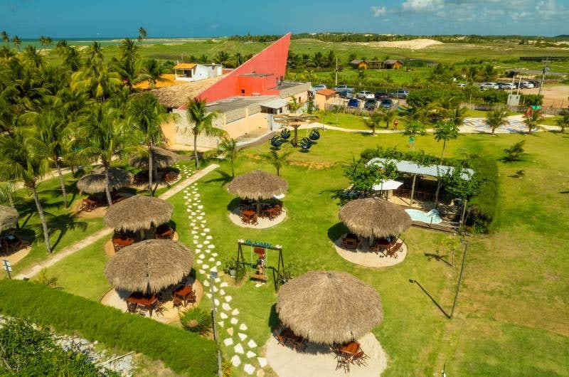 Vista aérea do beach club em Maracajaú, com gramado e quiosques